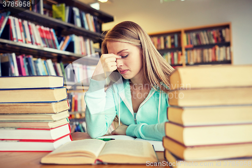 Image of bored student or young woman with books in library