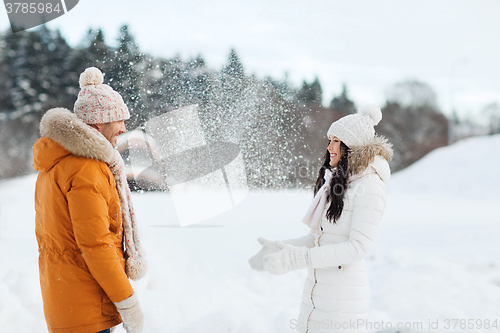 Image of happy couple playing with snow in winter