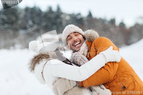 Image of happy couple hugging and laughing in winter