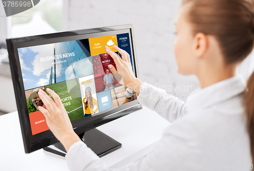 Image of woman with web pages on touchscreen in office