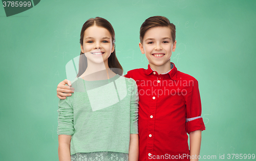 Image of happy boy and girl hugging over green chalk board