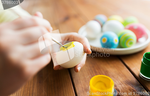 Image of close up of woman hands coloring easter eggs
