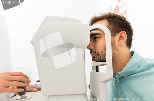 Image of optician with autorefractor and patient at clinic