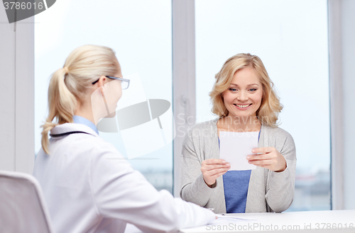 Image of doctor giving prescription to woman at hospital