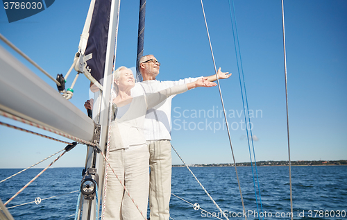 Image of senior couple enjoying freedom on sail boat in sea