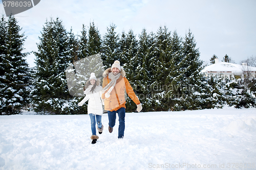 Image of happy couple running in winter snow