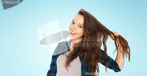 Image of happy teenage girl holding strand of her hair