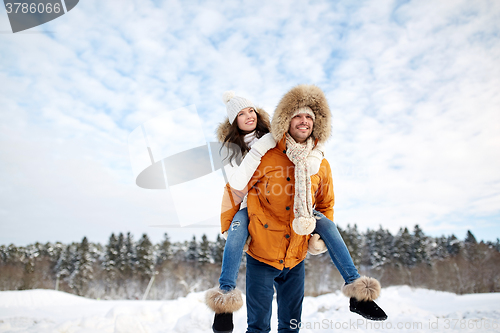 Image of happy couple having fun over winter background