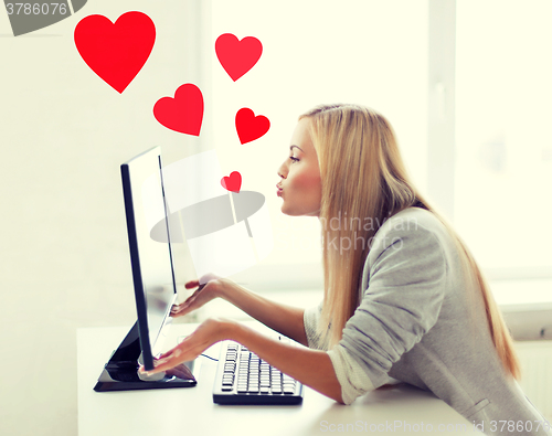 Image of woman sending kisses with computer monitor