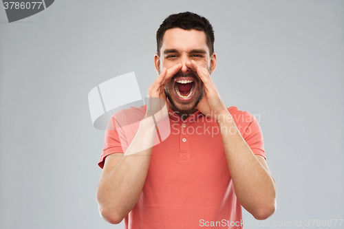 Image of angry shouting man in t-shirt over gray background