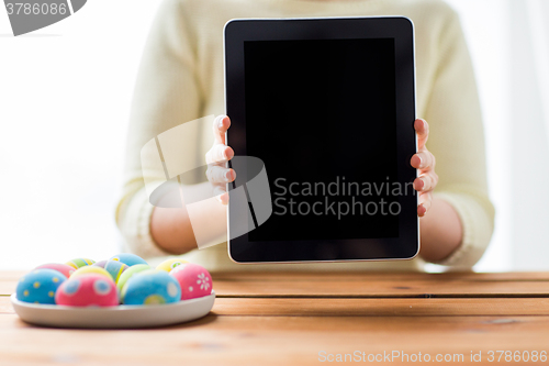 Image of close up of woman with tablet pc and easter eggs