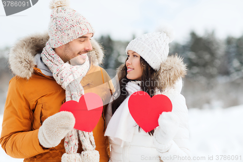 Image of happy couple with red hearts over winter landscape