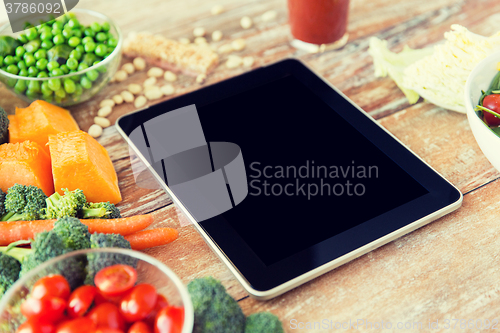 Image of close up of blank tablet pc screen and vegetables