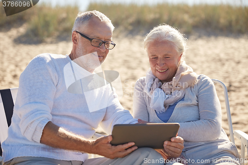 Image of happy senior couple with tablet pc on summer beach