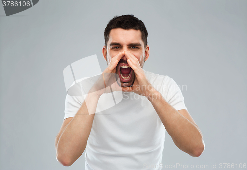 Image of angry shouting man in t-shirt over gray background