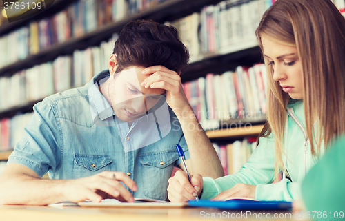 Image of students writing to notebooks in library