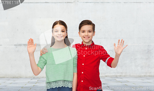 Image of happy boy and girl waving hand