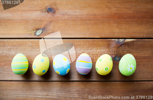 Image of close up of colored easter eggs on wooden surface