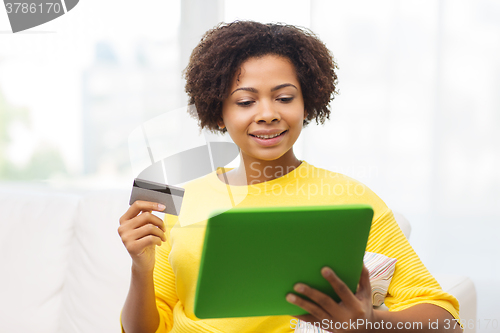 Image of happy african woman with tablet pc and credit card