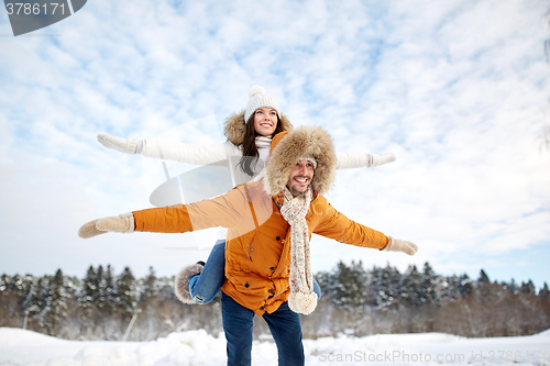 Image of happy couple having fun over winter background