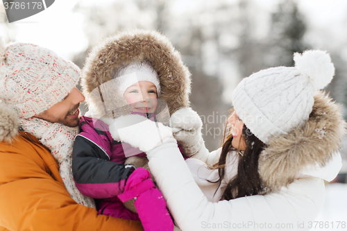 Image of happy family with child in winter clothes outdoors