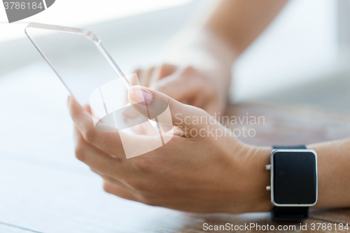 Image of close up of hands with smart phone and watch