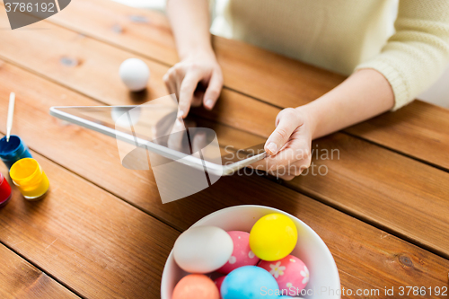 Image of close up of woman with tablet pc and easter eggs