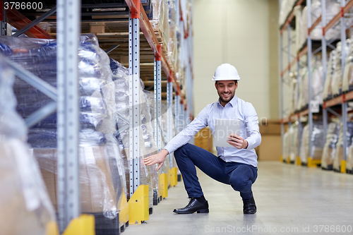 Image of happy businessman with tablet pc at warehouse