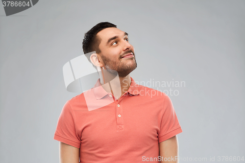 Image of smiling man looking up over gray background