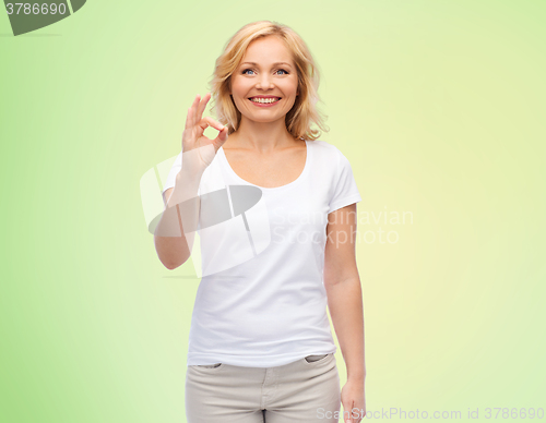 Image of happy woman in white t-shirt showing ok hand sign