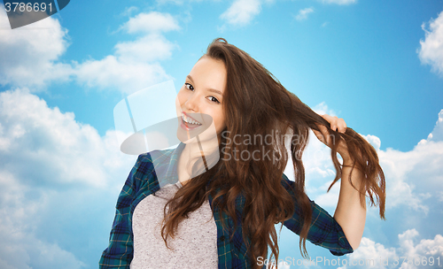 Image of happy teenage girl holding strand of her hair
