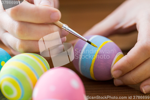 Image of close up of woman hands coloring easter eggs