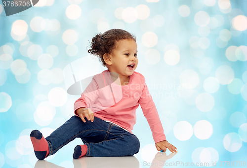Image of smiling little baby girl sitting on floor