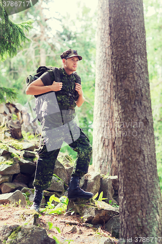 Image of young soldier with backpack in forest