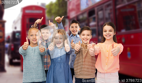 Image of happy children showing thumbs up over london city