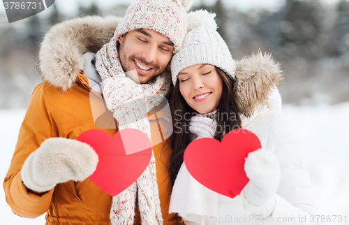 Image of happy couple with red hearts over winter landscape