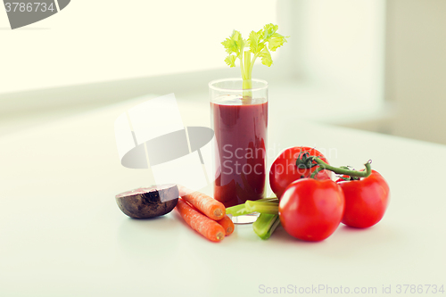 Image of close up of fresh juice and vegetables on table