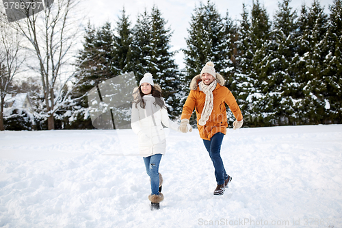 Image of happy couple running in winter snow