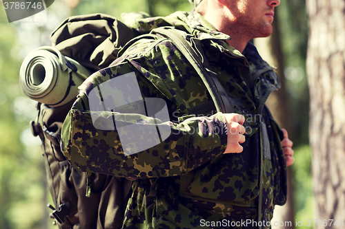 Image of close up of young soldier with backpack in forest