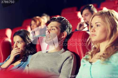 Image of happy friends watching horror movie in theater