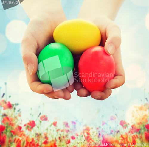 Image of close up of kid hands holding colored eggs