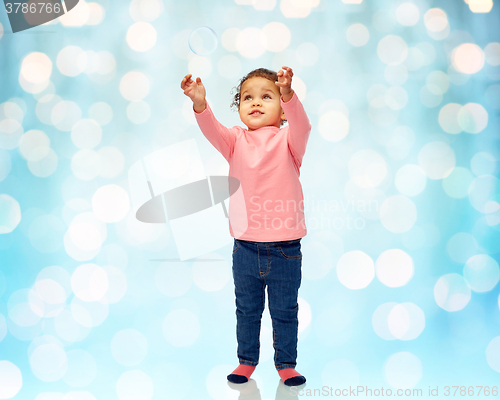 Image of little baby girl playing with soap bubble