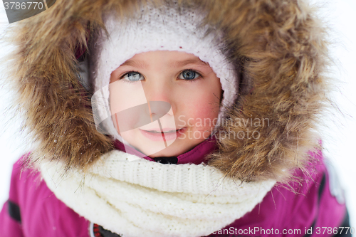 Image of face of happy little kid or girl in winter clothes