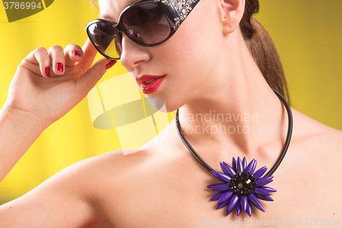 Image of Lifestyle fashion portrait of stylish  young woman in trendy sunglasses ,bright  necklace . Summer bright colors.