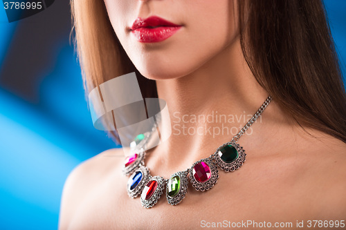 Image of necklace on the neck. ruby and emerald