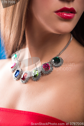 Image of necklace on the neck. ruby and emerald