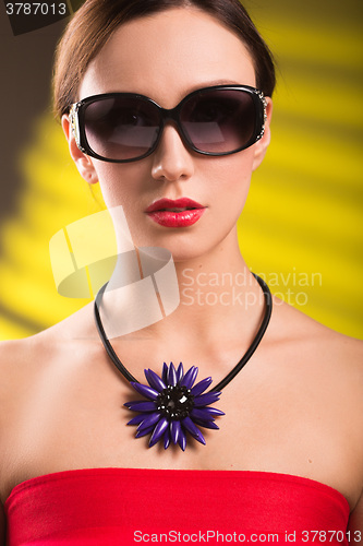 Image of Lifestyle fashion portrait of stylish  young woman in trendy sunglasses ,bright  necklace . Summer bright colors.