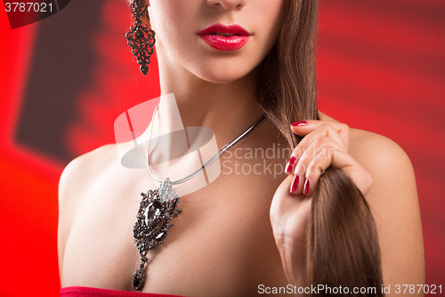 Image of necklace on female neck. girl holding hands. sexy red lips.