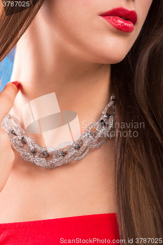 Image of necklace on female neck. girl holding hands. sexy red lips.