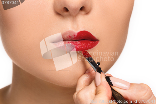 Image of Beautiful female lips with make-up and brush